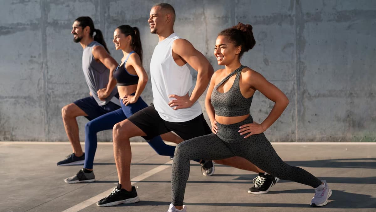 Group of people performing lunges outdoors, demonstrating effective exercise techniques for strength and fitness
