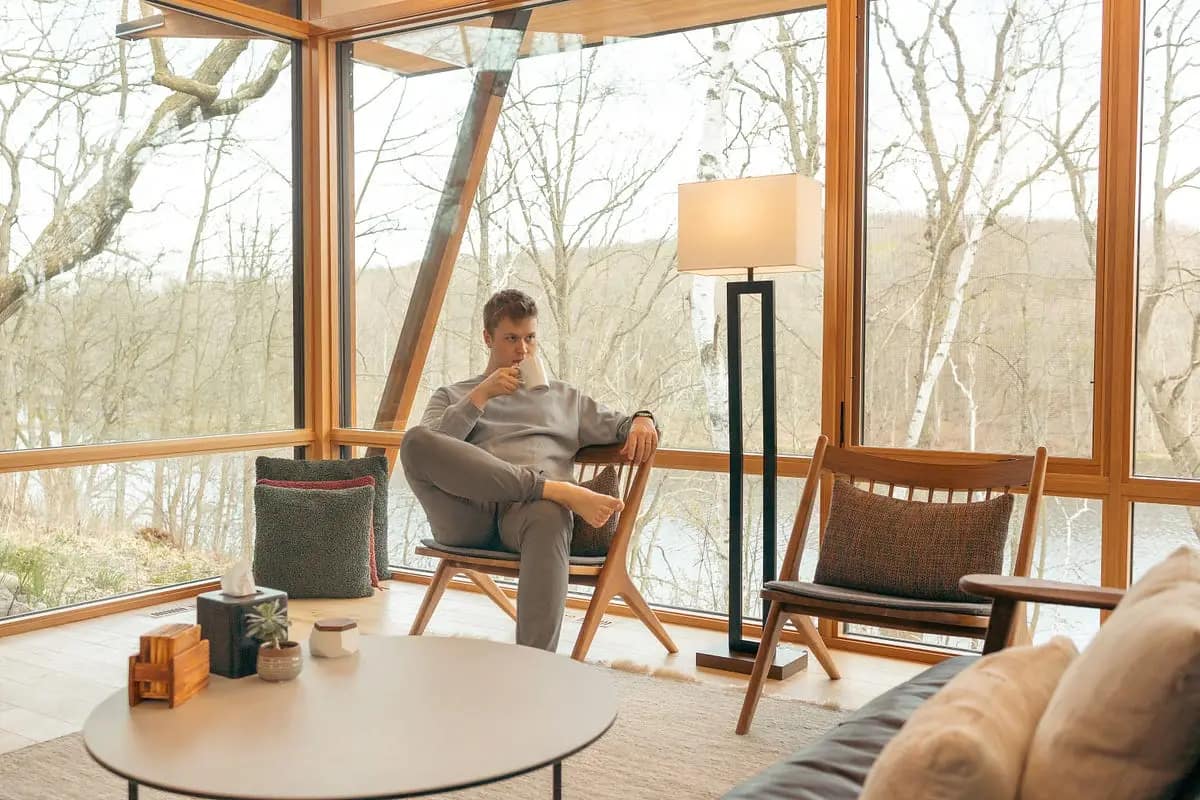 The Minimalist Lifestyle — a man enjoying coffee in a simple, peaceful living space with natural light and wooden decor.