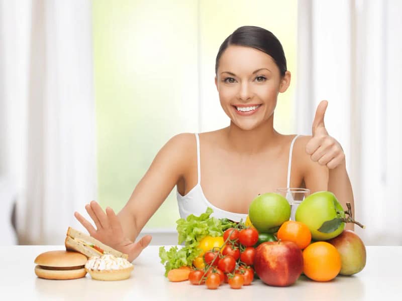 Smiling woman choosing Healthy Food like fruits and vegetables instead of junk food, promoting clean and balanced eating habits.